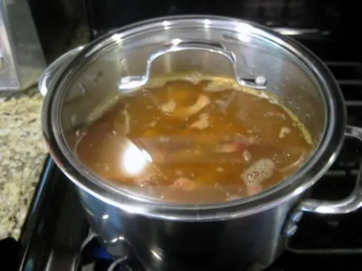 large soup pot filled with cider vinegar, old bay, spices and shrimp. covered with a lid and boiling for old bay shrimp
