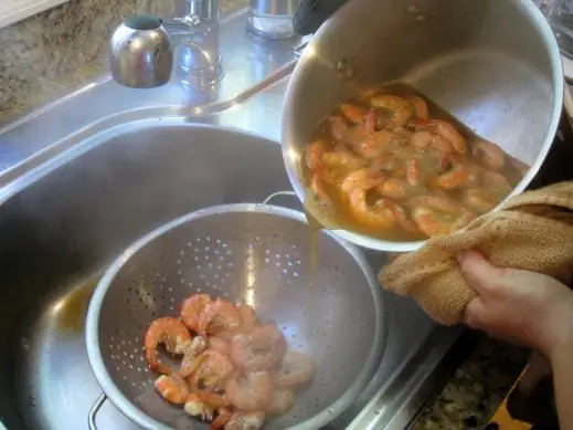 draining cooked old bay shrimp into a colander
