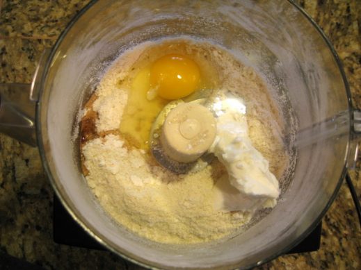 bowl of food processor with ingredients to make a paleo pie crust
