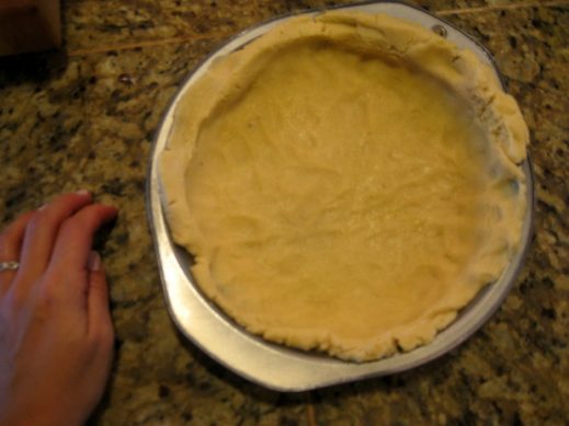 pressing uncooked paleo pie crust dough into a pie pan