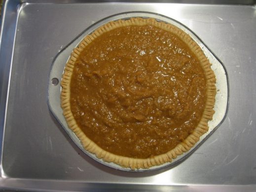 paleo pumpkin pie on a baking sheet ready to go into the oven to bake