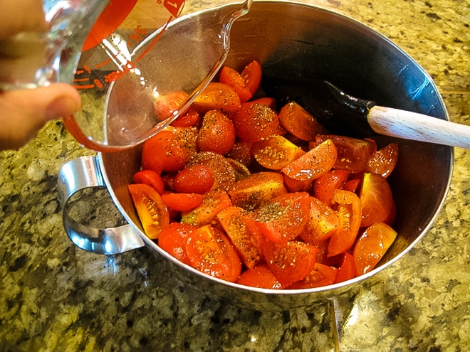 silver mixing bowl with ingredients for tomato salad