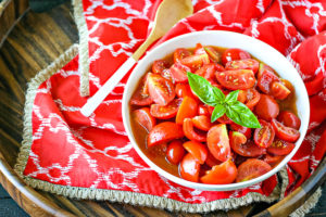 bowl of tomato salad made with jersey tomatoes with basil on top