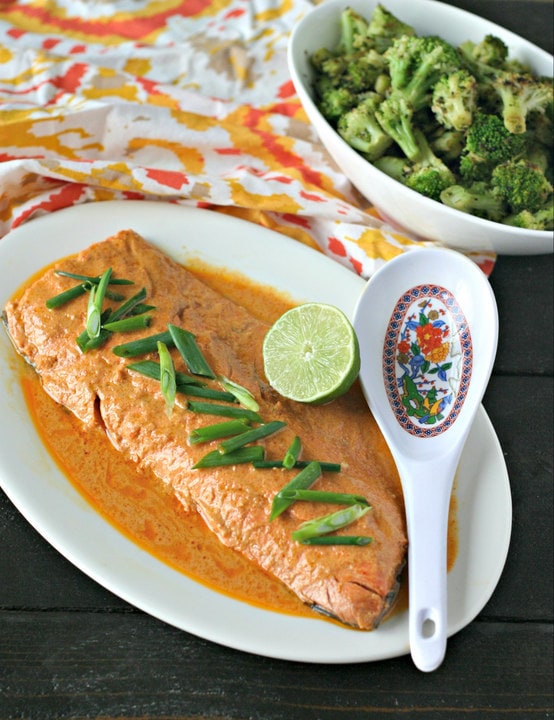 whole fillet of wild salmon in red curry sauce with lime and bowl of broccoli