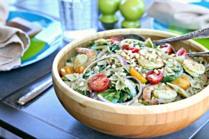 wood bowl with pesto pasta salad