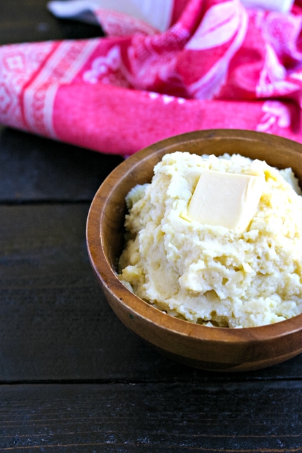 easy instant pot mashed potatoes served in a wood bowl topped with butter