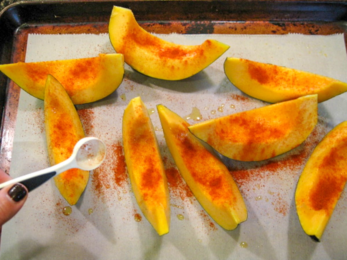 cut acorn squash with paprika on a baking sheet about to go into the oven