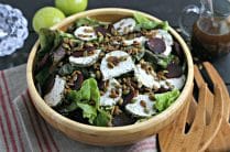 close up of wood salad bowl with thanksgiving salad topped with toasted pumpkin seeds