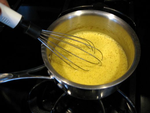 whisking non-dairy milk and spices to make turmeric milk