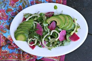 oval white platter with watercress salad, avocado, fennel and watermelon radish