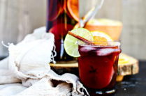 pitcher of fall sangria with cut orange and frayed linen