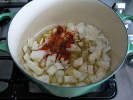 large dutch oven with olive oil, roughly chopped onion and garlic and spices to make Garlic Soup