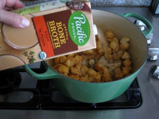 adding Beef Bone Broth to a pot of ingredients to make Garlic Soup