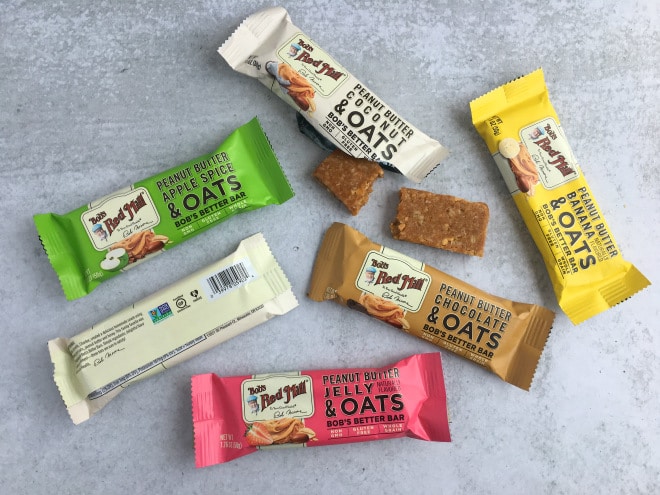 five flavors of Bob's Better Bars in the wrappers with one opened and broken in half