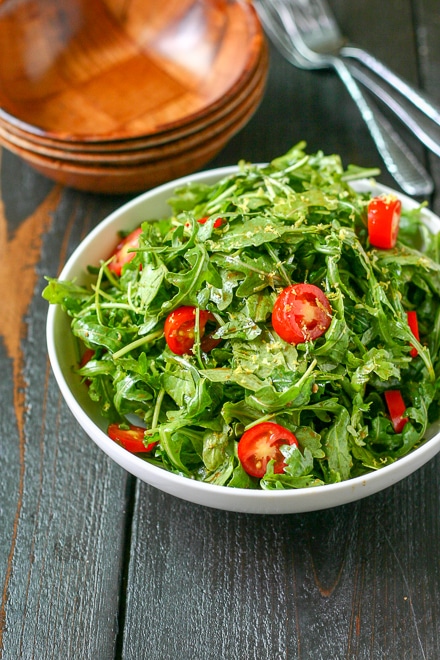 arugula salad with balsamic in a white bowl