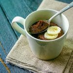 beige mug with microwave chocolate mug cake recipe topped with sliced banana