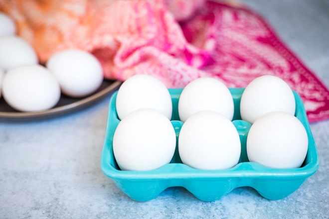 white eggs in a blue ceramic egg holder for coddled eggs