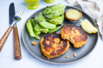 plate of salmon cakes with lemon, lettuce, and dipping sauce