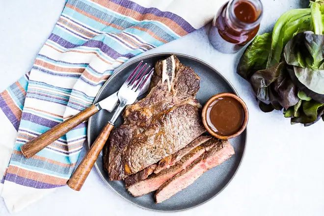 overhead shot of sliced steak with homemade steak sauce next to lettuce