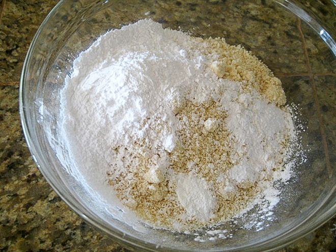 combining gluten-free flours in a mixing bowl for blueberry muffin recipe
