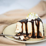 close up of a slice of ice cream cake covered in chocolate sauce