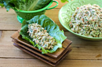 Tuna Salad in a romaine lettuce leaf in front of a bowl of more tuna salad
