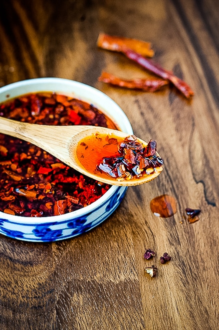 small bowl of homemade chili oil with a wood spoon