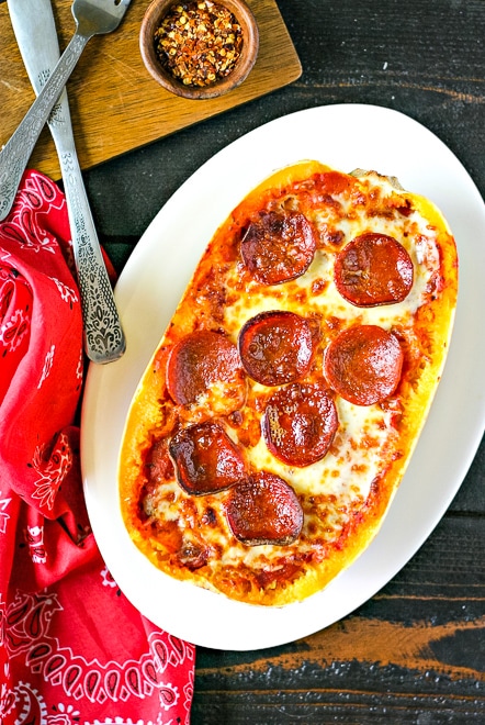 overhead of cooked spaghetti squash topped with pizza sauce, melted cheese and pepperoni