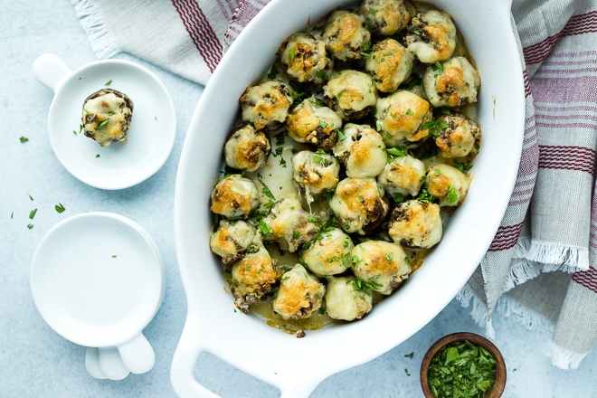 white baking dish with cheesesteak stuffed mushrooms topped with chopped parsley
