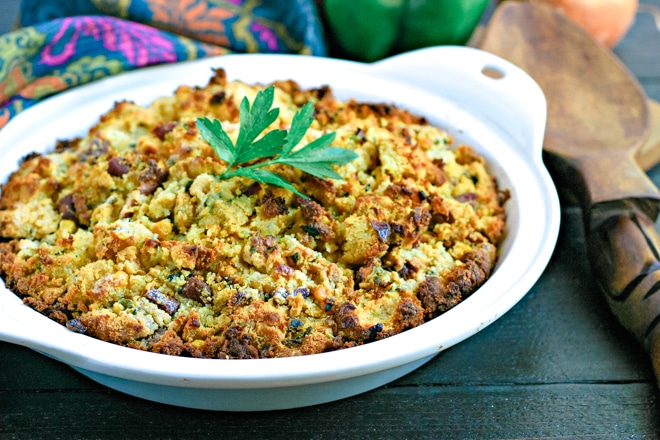white baking dish with cornbread stuffing topped with parsley
