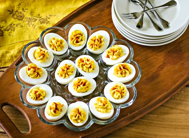 platter of deviled eggs with truffle salt next to serving plates