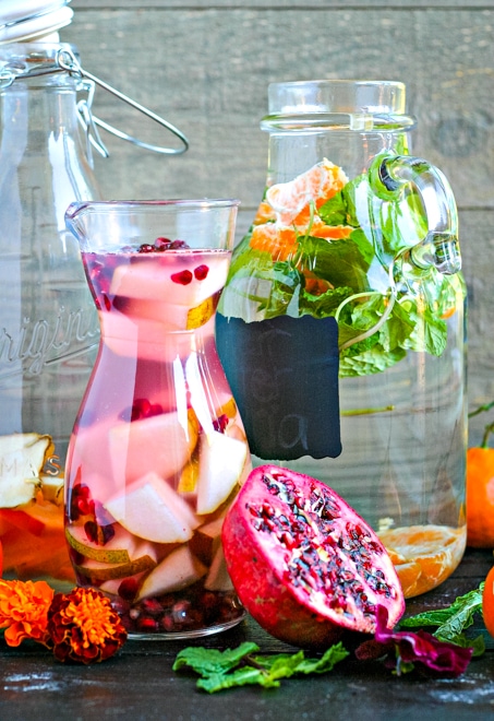large glass pitchers filled with fruit and herb water