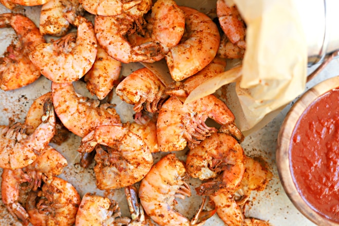 cooked shrimp tossed with old bay seasoning on a large tray