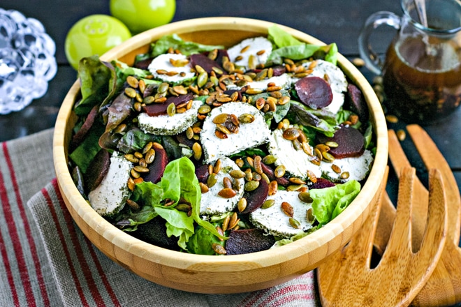 salad bowl with festive thanksgiving salad topped with crispy pumpkin seeds