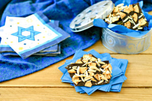 hanukkah candy on blue napkins with a silver tin filled with more candy