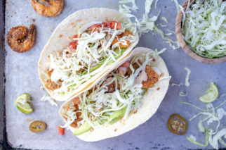 two crispy shrimp tacos with shredded cabbage