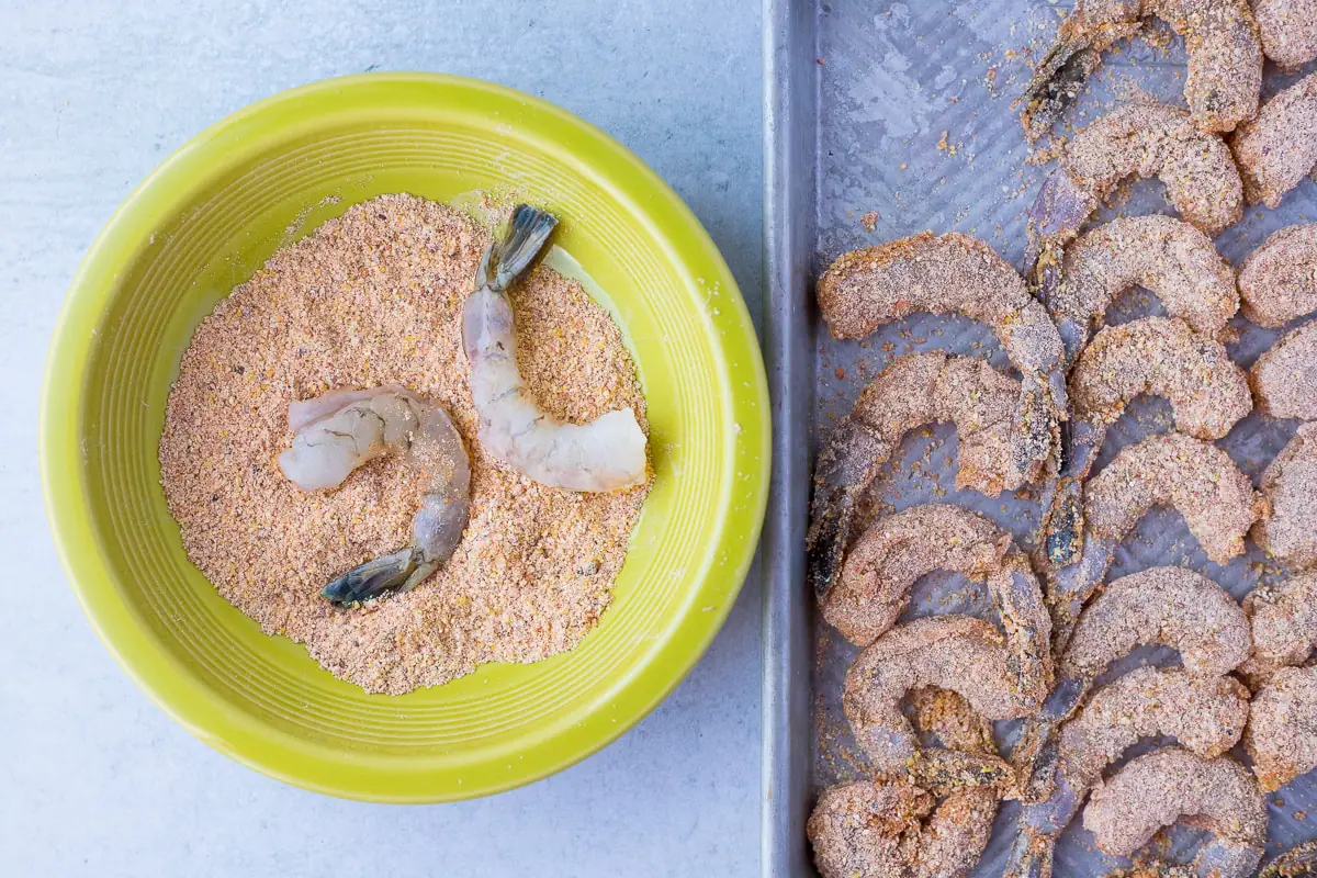 breading shrimp in cornmeal and taco seasoning for crispy shrimp tacos