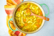 large pot of turmeric chicken soup with ladle in it ready to serve