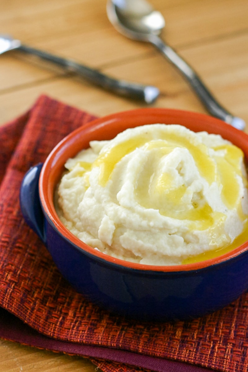 bowl of cooked mashed cauliflower topped with butter