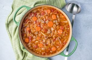 large round green pot with soup and a green kitchen towel