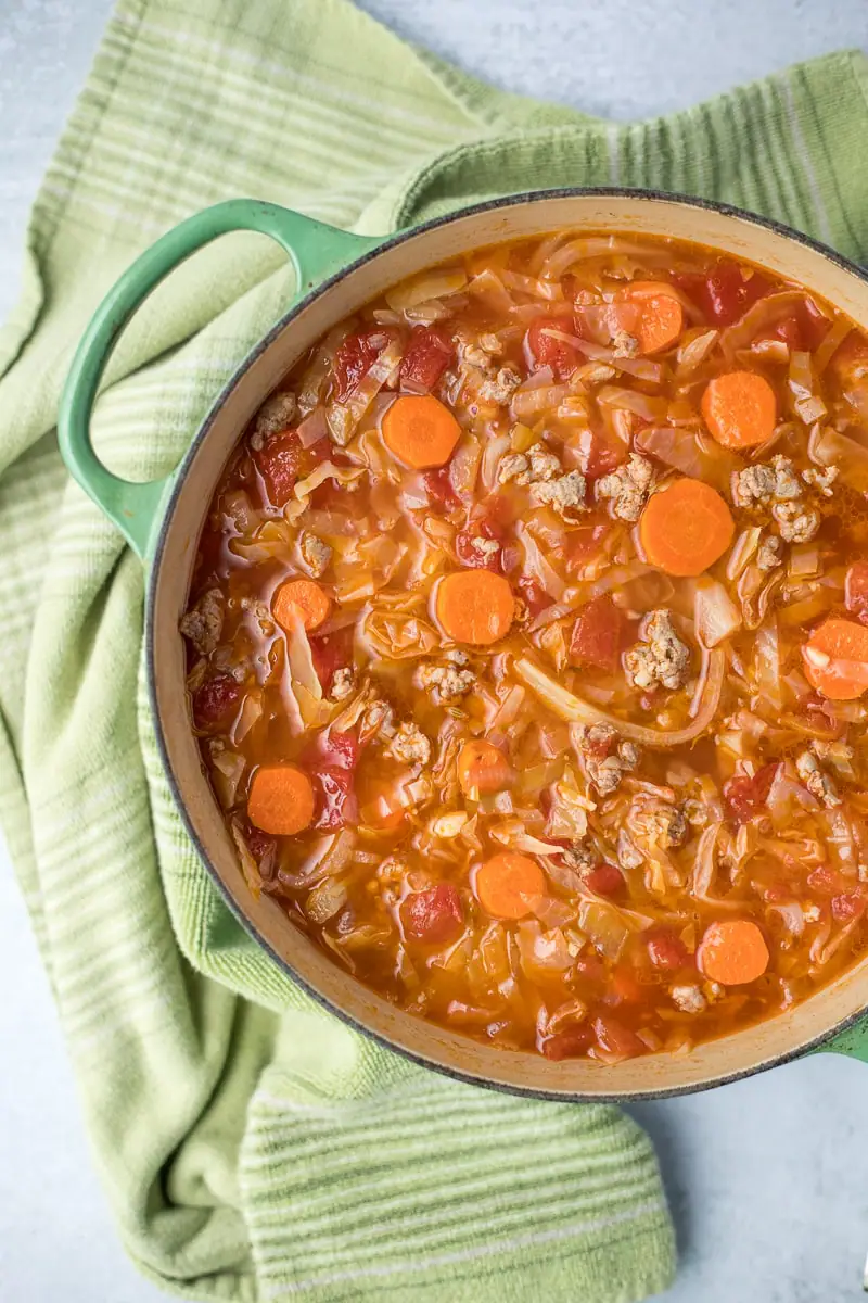 large pot filled with soup next to a green kitchen towel