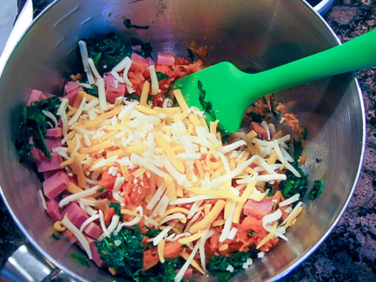 mixing chopped ham, spinach and cheese in a mixing bowl