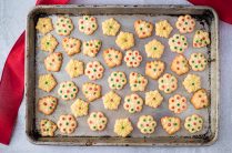 cookie sheet with decorated butter cookies and red ribbon