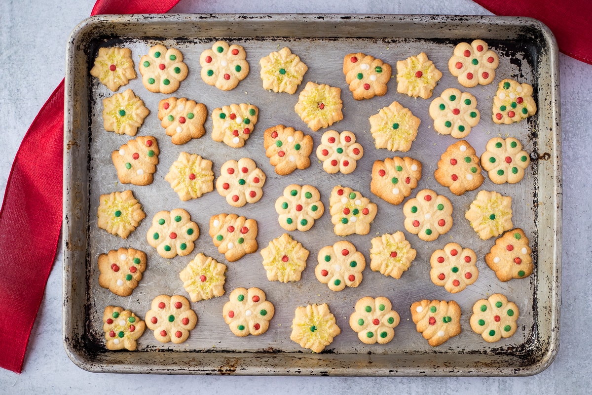 cookie sheet with decorated butter cookies and red ribbon