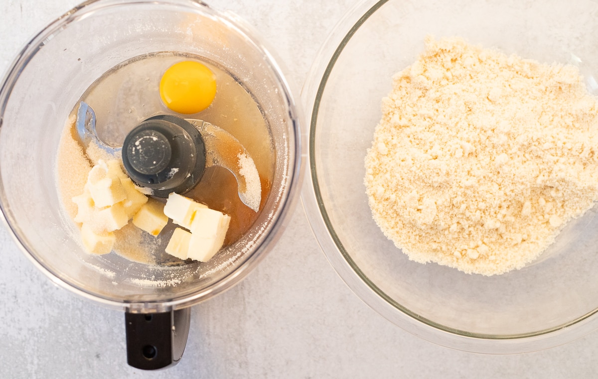 mixing bowl of almond flour next to food processor bowl with butter, sugar, and egg 