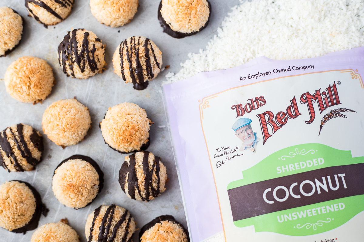 mini macaroons on a baking sheet with shredded coconut 