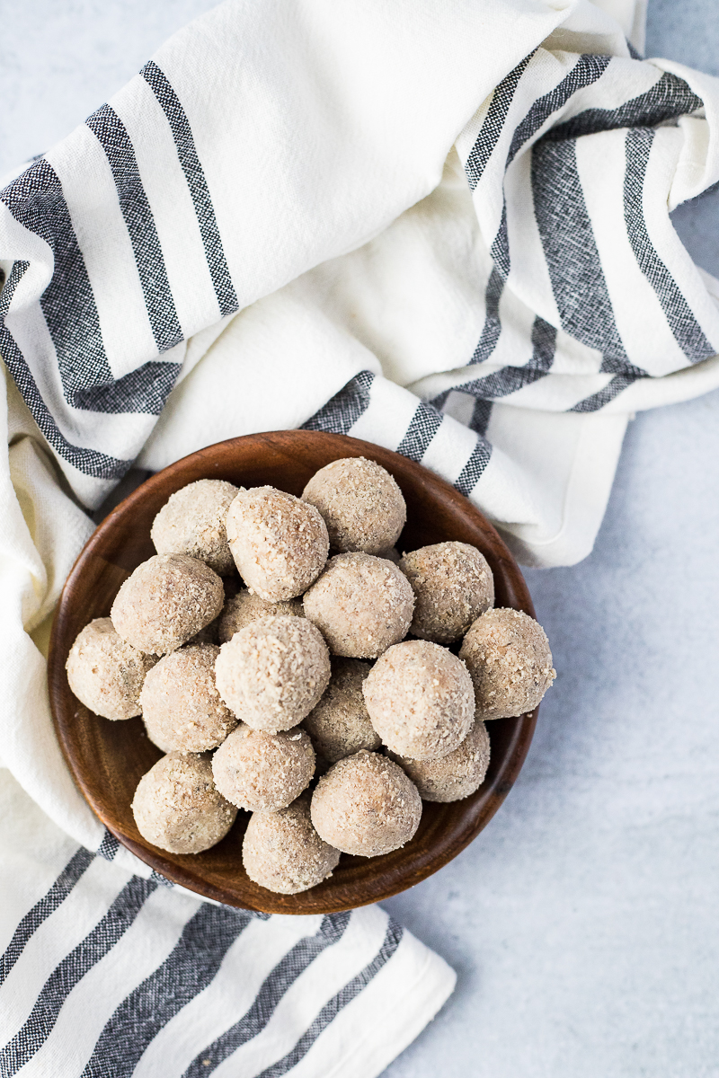 small wood bowl of energy balls with black and white linen